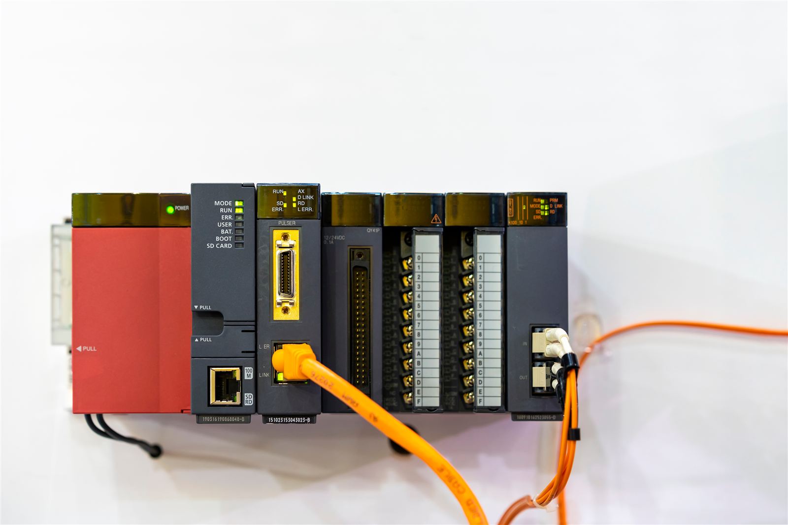 PLC rack with CPU and I/O modules connected by Ethernet patch cables